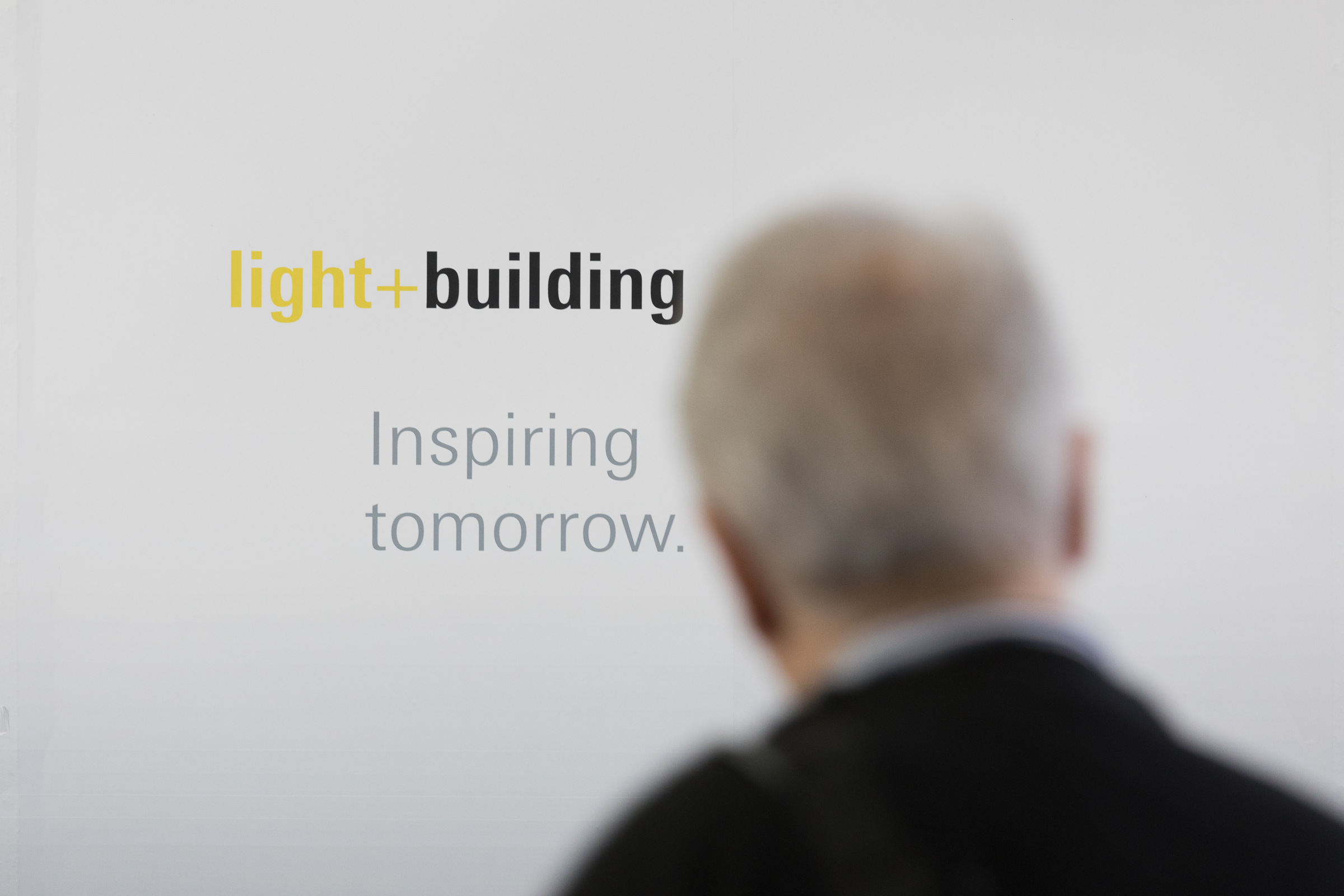 Person vorm Light + Building Logo