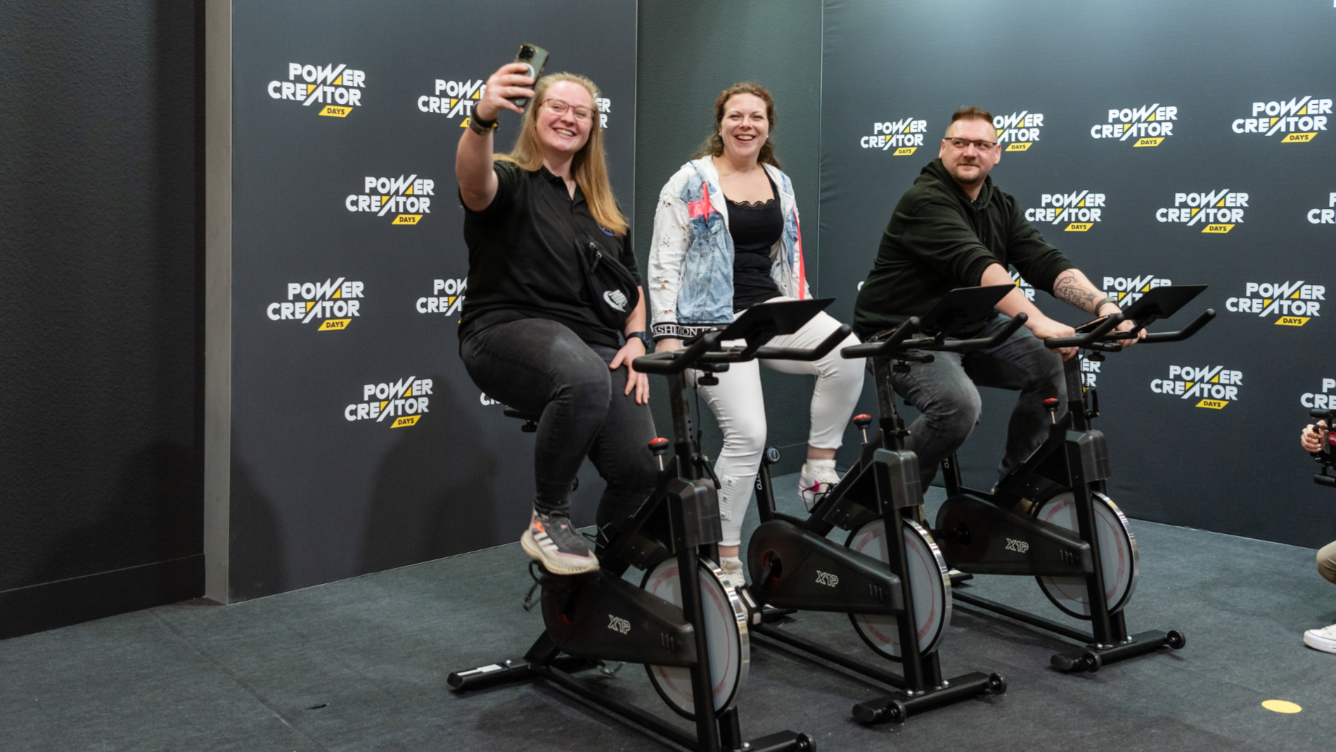 Drei Messebesucher sitzen auf E-Bikes