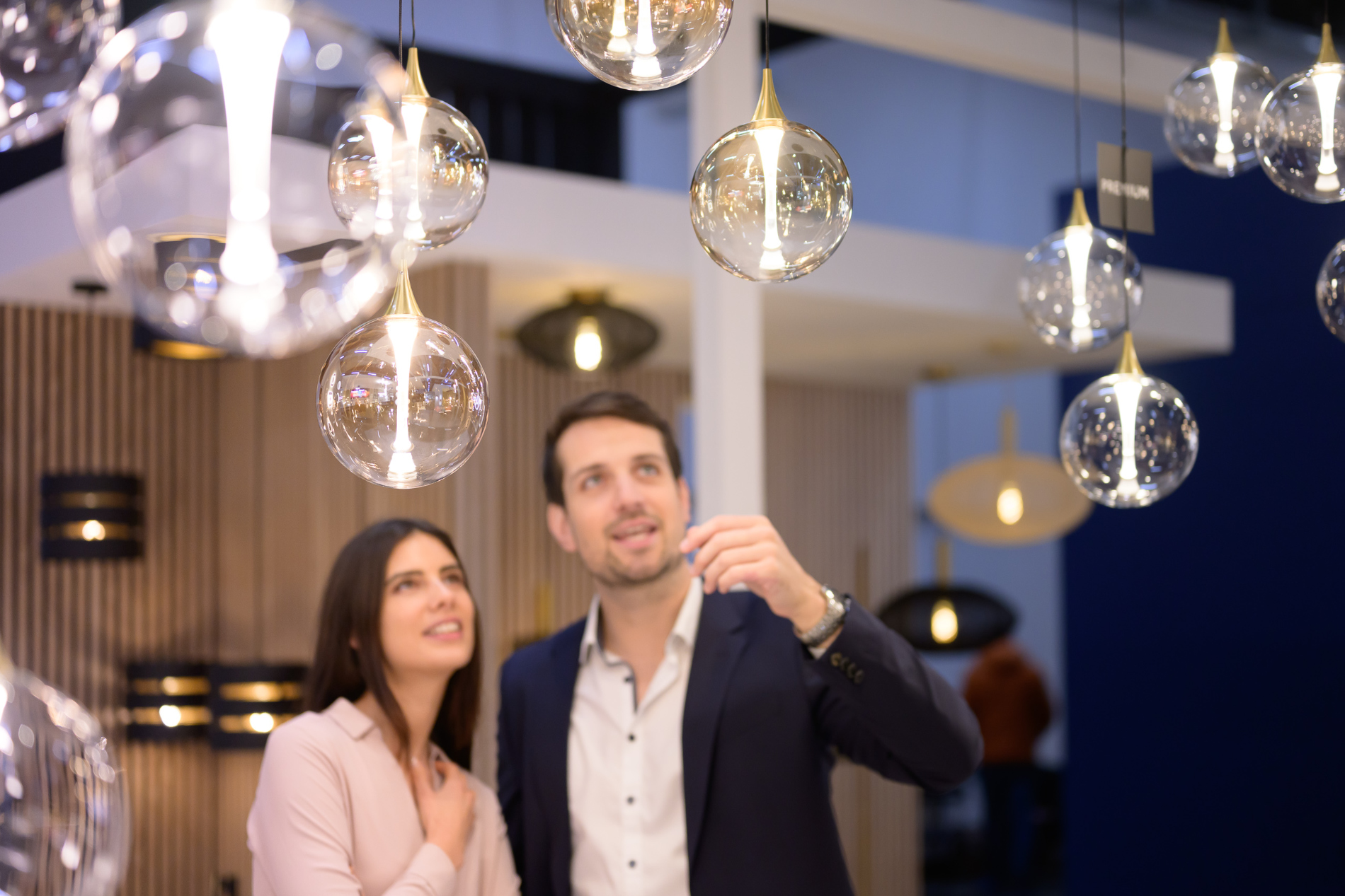 Two trade fair visitors look at lights